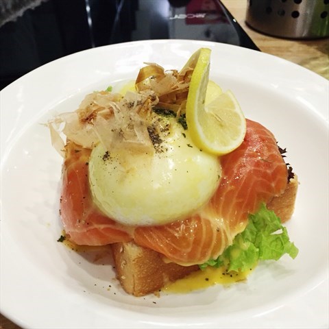 Two perfectly poached eggs with smoked salmons lays on thick toast, topped with Hollandaise sauce.